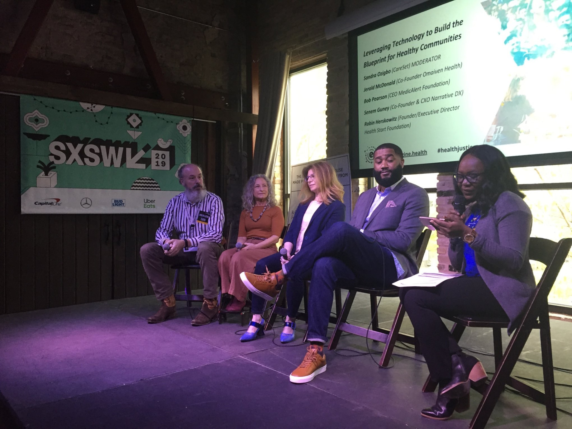 Jerold McDonald in a grey blazer seated on a SXSW 2019 panel beside the SXSW banner
